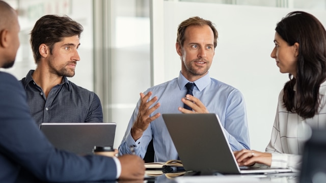 Professionals talking at a desk